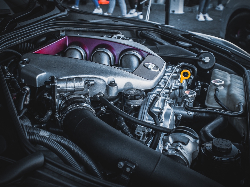 Close-up of reconditioned engine parts in a Kia vehicle's engine bay with detailed components visible.